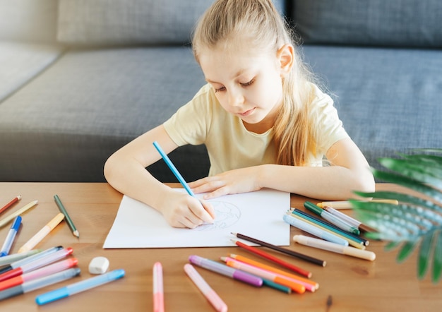 Child girl drawing with colorful pencils