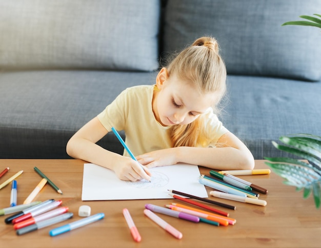 カラフルな鉛筆で描く子供の女の子