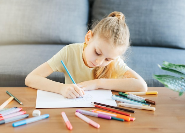 Child girl drawing with colorful pencils