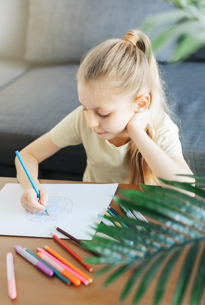 Child girl drawing with colorful pencils