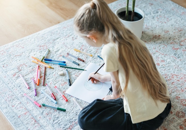 カラフルな鉛筆で描く子供の女の子