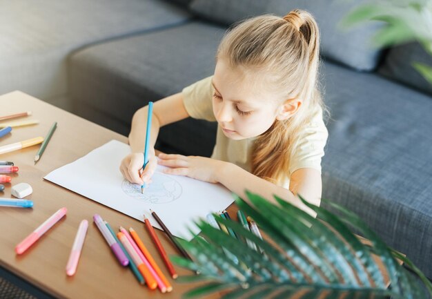 Child girl drawing with colorful pencils