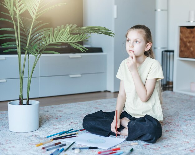 Child girl drawing with colorful pencils