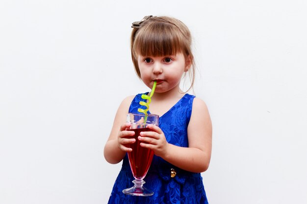 Child girl drinking gooseberry refreshment with fun straw, white background