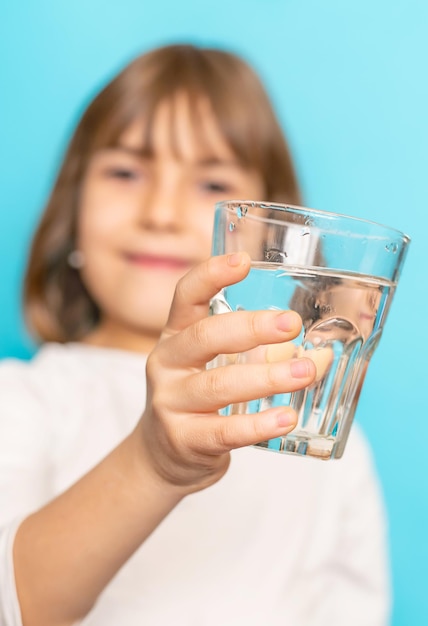 Child girl drinks water from a glass Selective focus