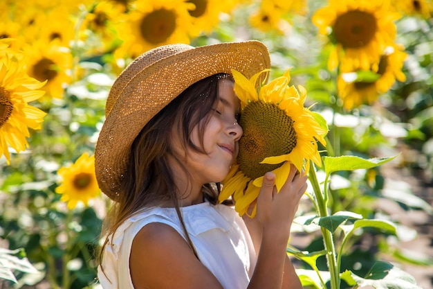 Child girl in a field of sunflowers. Selective focus. Kid.