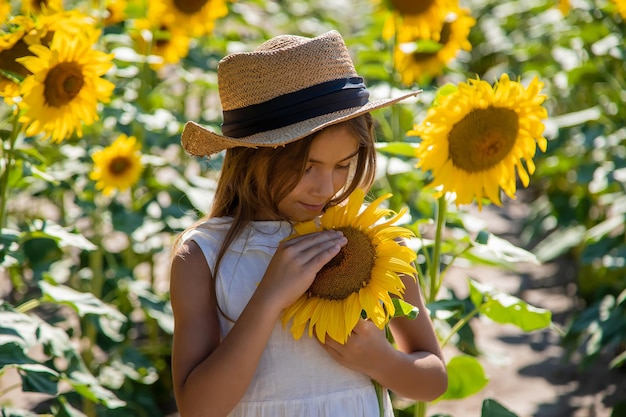 Child girl in a field of sunflowers. Selective focus.