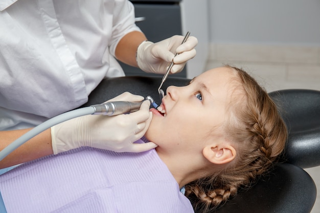 Child girl having professional dental cleaning in dentist office