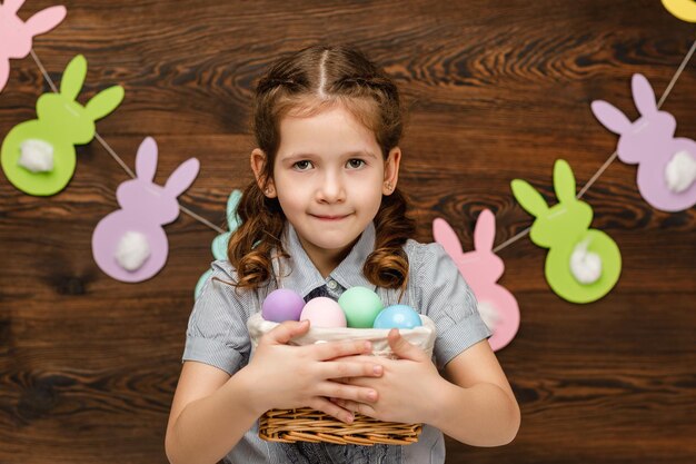 Foto cestino della tenuta della ragazza del bambino con pasqua