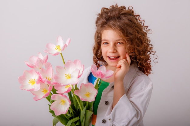 A child a girl holding a bouquet of yellow tulips