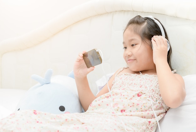 Ребенок девочка, слушать музыку с смартфона.