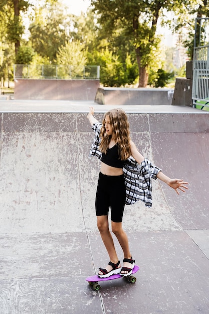 페니 보드 또는 스케이트 보드를 타는 어린 소녀 어린이를 위한 스포츠 장비 스케이트 공원 운동장에 페니 보드가 있는 십대