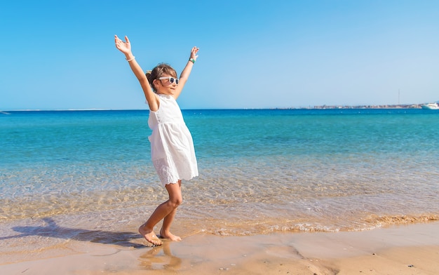 Ragazza del bambino sulla spiaggia del mare