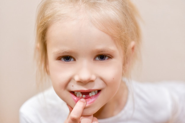 Foto la ragazza del bambino mostra il cambio del dente da latte