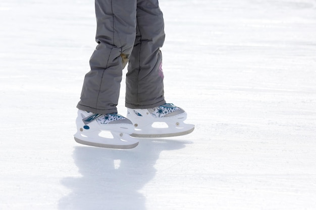 Photo child girl skates on ice rink