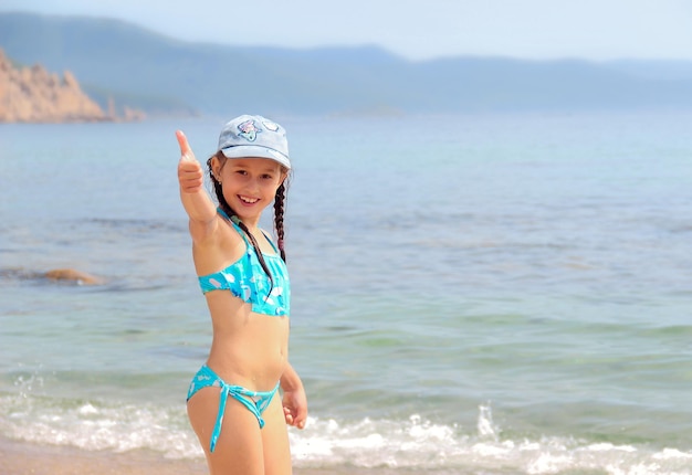 девочка стоит на пляже у моря