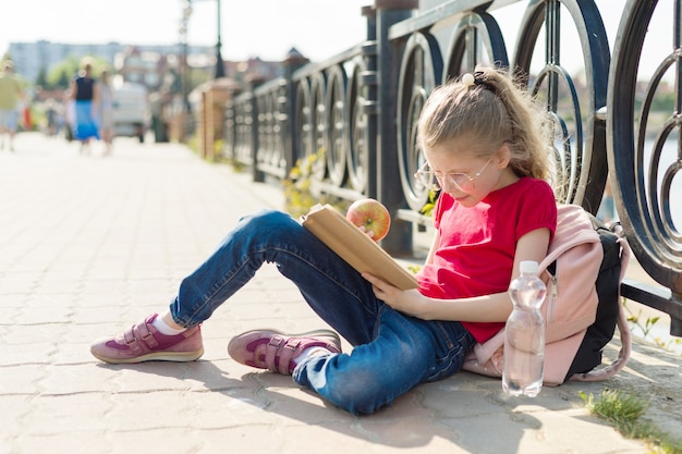 Child girl student wearing glasses reading book