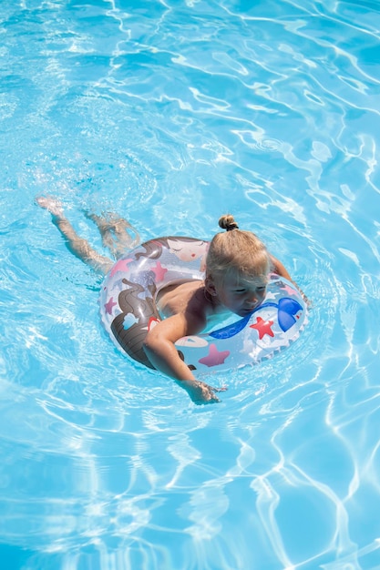 Child girl swims with an inflatable ring in the pool Top view flat lay