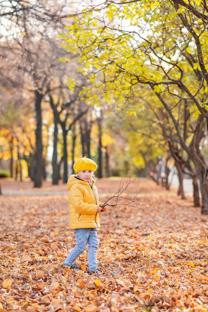 Una bambina cammina nel parco autunnale