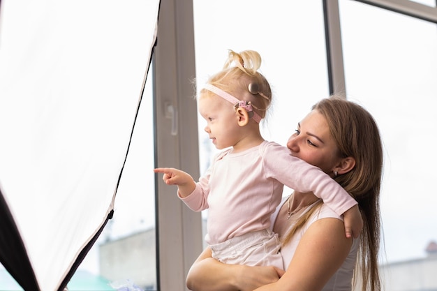 Child girl with cochlear implant with her mother at home Hear impairment and deaf community concept