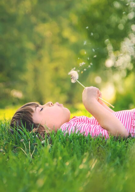 Photo child girl with dandelions in the park selective focus