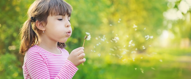 Photo child girl with dandelions in the park. selective focus.