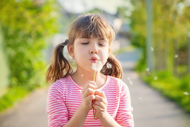 Child girl with dandelions in the park. Selective focus.