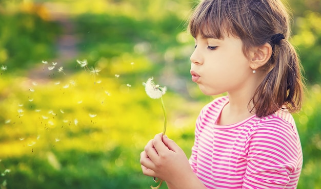 Child girl with dandelions in the park