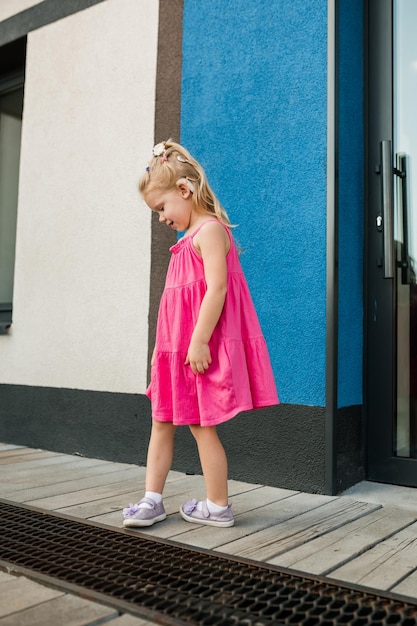 Photo child girl with hearing aids and cochlear implants having fun outdoor speak and playing