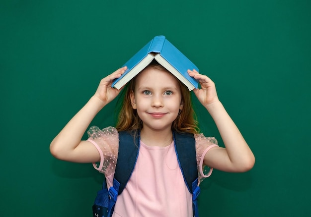 책가방과 책을 손에 들고 있는 어린 소녀