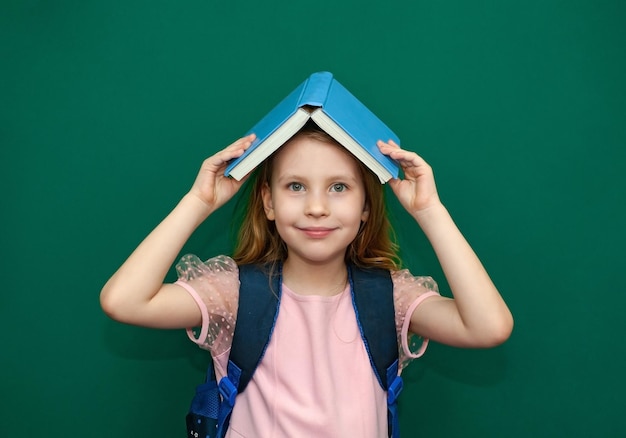 Child girl with a schoolbag and books in hands