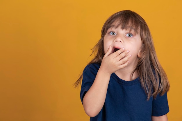 口を開けてあくびをする子供女の子