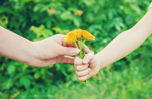 Il bambino regala il fiore a sua madre messa a fuoco selettiva