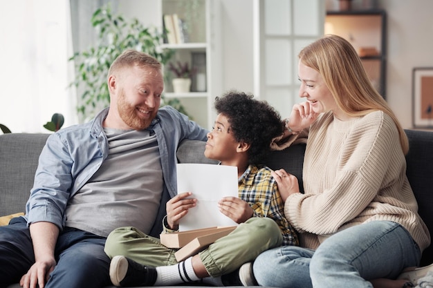 child giving drawing to his foster parents