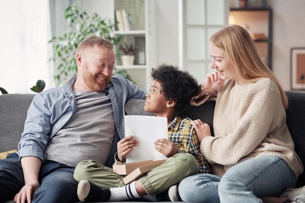 Child giving drawing to his foster parents