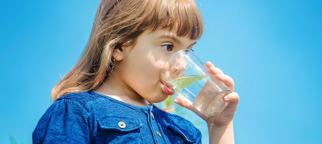 Bicchiere d'acqua per bambini. messa a fuoco selettiva. natura.