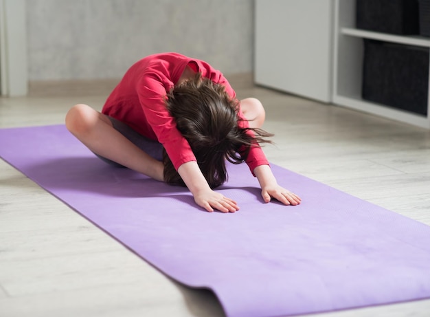 Child goes in for sports at home home workout girl stretches forward