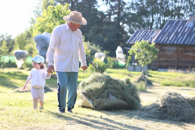 子供と祖父は干し草を収穫しました