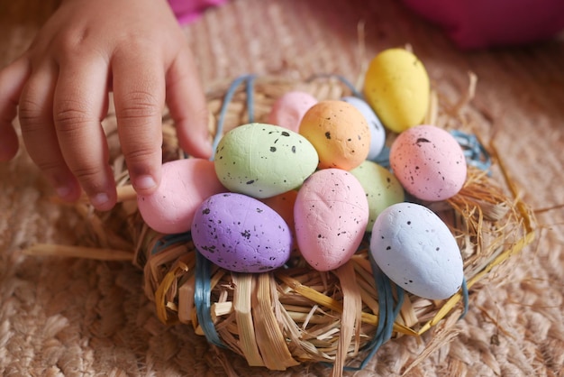 Child hand holding a bowl of easter eggs