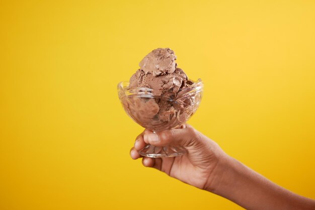 child hand holding chocolate ice cream with copy space