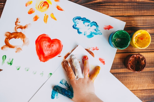Фото Рука ребенка рисует красочную мозаику ребенок рисует ладонь на белых листах красками
