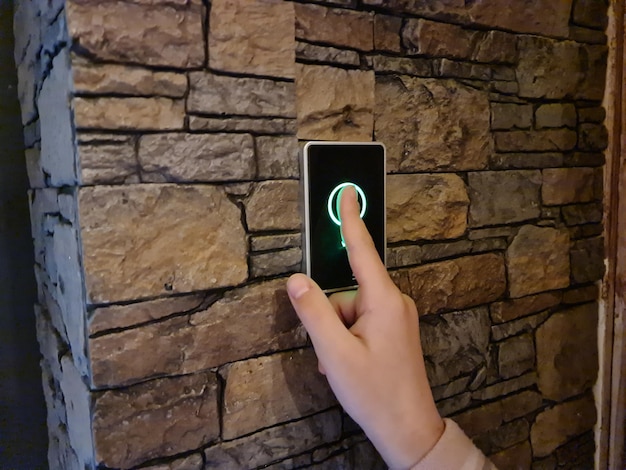 Child hand presses touch button exit in stairwell