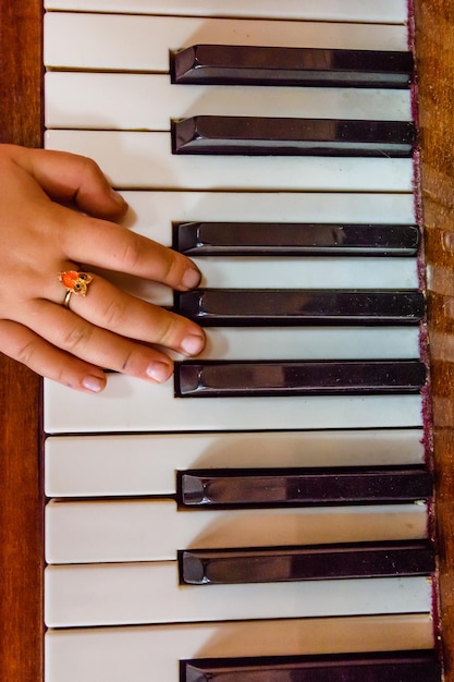 光沢のあるピアノの鍵盤に子供の手 トップ ビュー
