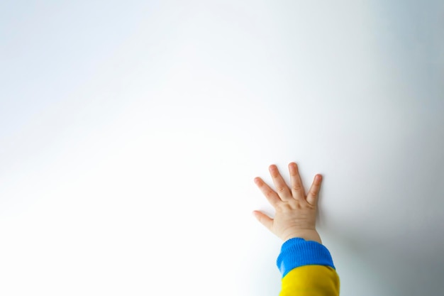 Mano del bambino su uno sfondo bianco concetto di aiuto dei rifugiati ucraini