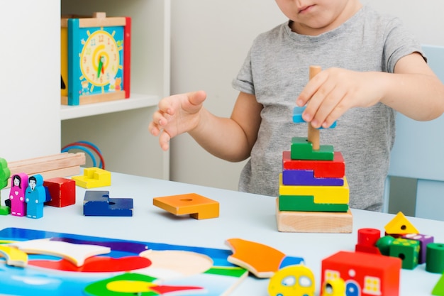 Child hands collect wooden puzzle