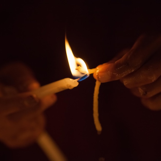 Child hands lightning candle on a dark background