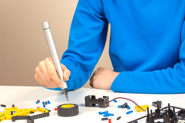 Child hands making a robot car