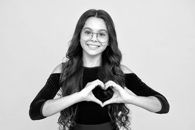 Child hands making sign heart by fingers Valentines Day Dreaming cute teen child with red heart Happy face positive and smiling emotions of teenager girl