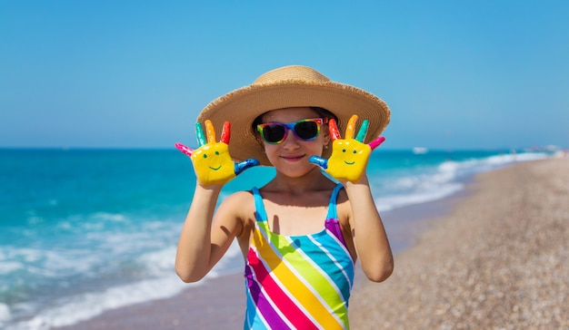 Child hands painted with paints on the sea. Selective focus. Kid.