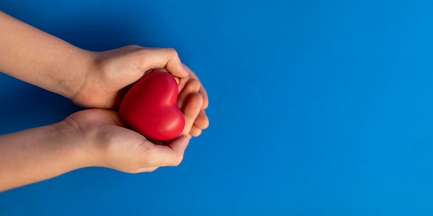 Photo child hands with red heart concept of solidarity and love of neighbor